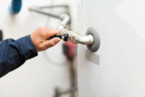 Man Inspecting Water Heater In Need of Repair in Easton PA