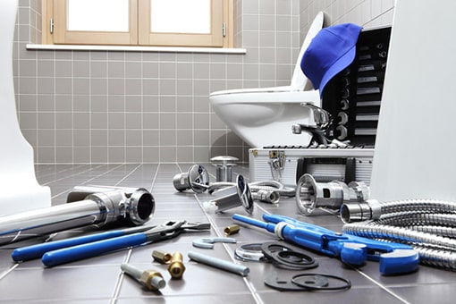 Emmaus Plumber's Tools Scattered on Floor While Repairing Toilet