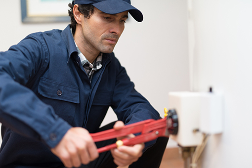 Plumber Repairing Broken Water Heater in a Forks Township Commercial Property