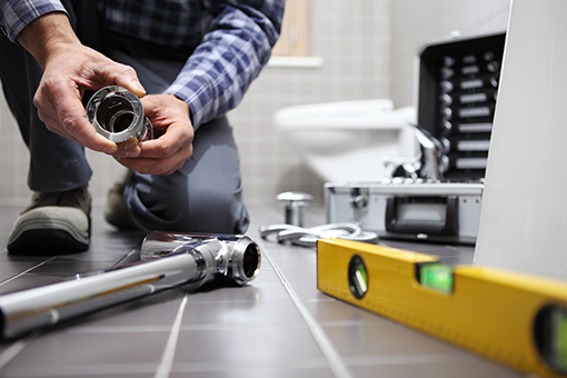 Palmerton Plumber Holding Materials To Install Bidet and Fix Toilet of a Commercial Property