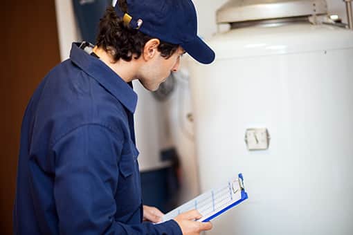 Skilled Plumber Inspecting Broken Water Heater to be Repaired in Trexlertown PA
